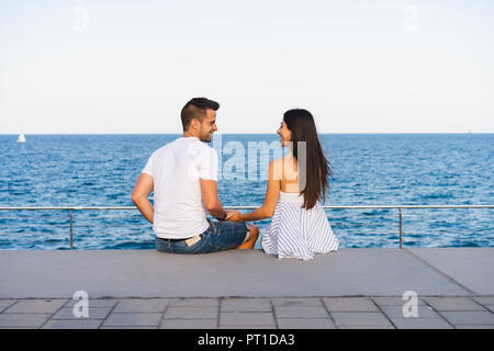 Happy young couple standing by the sea Banque D'Images