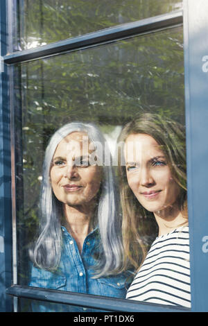 Mère et fille à la fenêtre de Banque D'Images