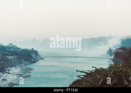 Matin dans les montagnes. Le Gange dans les contreforts de l'Himalaya. L'Inde. vue de Lakshman Jhula bridge tôt le matin de la fumée sur l'eau. Banque D'Images