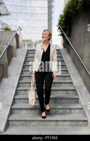 Smiling businesswoman walking en bas Banque D'Images