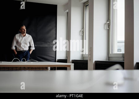 Businessman in office looking out of window Banque D'Images