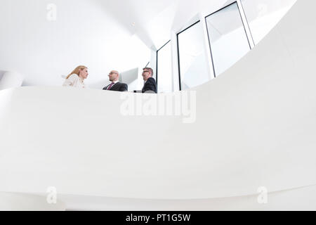 Poland, Warzawa, femme d'en parler avec deux hommes d'affaires Banque D'Images