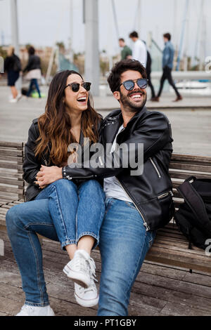 Espagne, Barcelone, happy young couple reposant sur un banc Banque D'Images