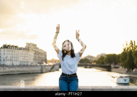 France, Paris, portrait of happy young woman at River Seine au coucher du soleil Banque D'Images