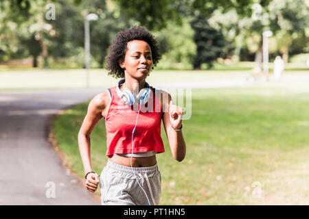 Young woman running in park Banque D'Images