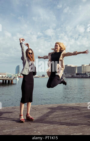 Espagne, Barcelone, deux jeunes femmes à la mode s'amusant Banque D'Images