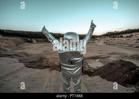 Spaceman raising arms sur une planète sans nom, avec Thumbs up Banque D'Images