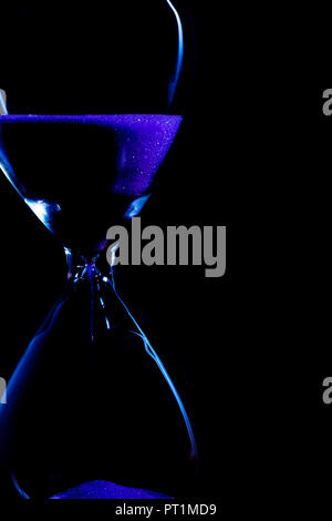 Hourglass silhouette bleu sur fond noir Banque D'Images