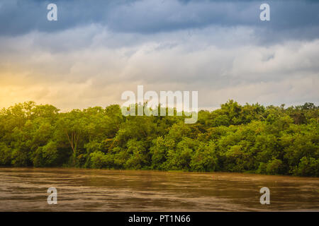 Belle pleine de l'eau boueuse de la rivière Mun avec forêt verte et bleu ciel nuageux dans la journée au parc national de Kaeng Tana, Ubon Ratchathani, Thaïlande. Banque D'Images