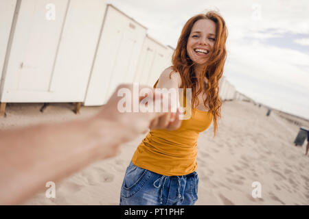 Smiling woman reaching out à la main de l'homme Banque D'Images