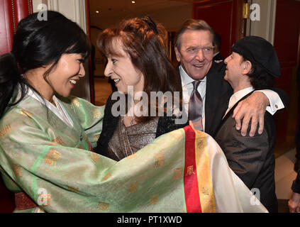 05 octobre 2018, Berlin : l'ancien chancelier allemand Gerhard Schroeder et son épouse sud-coréen Kim Soyeon, qui l'a épousé il y a cinq mois, d'être accueilli lors d'une réception à l'hôtel Adlon par Scorpions' chanteur Klaus Meine (R) et son épouse Gabi. Le couple est d'avoir leur fête de mariage. Environ 150 invités étaient attendus à la soirée. Photo : Kai-Uwe Wärner/dpa Banque D'Images