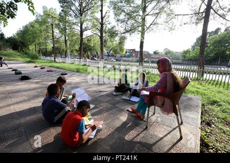 Islamabad, Pakistan. 5Th Oct, 2018. Un enseignant assiste à une classe lors d'une école de fortune mis en place dans un parc public à Islamabad, capitale du Pakistan, le 5 octobre 2018. La Journée mondiale des enseignants est célébrée le 5 octobre. Credit : Ahmad Kamal/Xinhua/Alamy Live News Banque D'Images