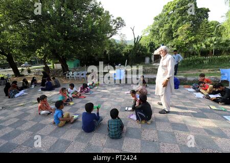 Islamabad, Pakistan. 5Th Oct, 2018. Un enseignant assiste à une classe lors d'une école de fortune mis en place dans un parc public à Islamabad, capitale du Pakistan, le 5 octobre 2018. La Journée mondiale des enseignants est célébrée le 5 octobre. Credit : Ahmad Kamal/Xinhua/Alamy Live News Banque D'Images