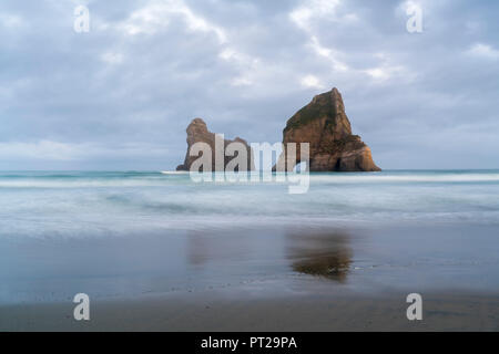 Moody ciel au-dessus de l'arche deux îles, Wharariki beach, Puponga, district de Tasmanie, île du Sud, Nouvelle-Zélande, Banque D'Images