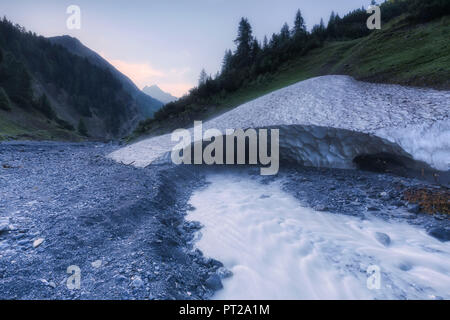 L'eau d'un ruisseau passe sous une arche de glace dans le Val Trupchun, Parc National Suisse, la vallée de l'Engadine, Grisons, Suisse, Europe, Banque D'Images