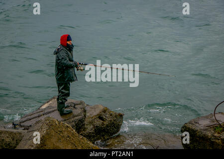 PUERTO VARAS, CHILI, septembre, 23, 2018 : pêcheur non identifiés debout dans un rocher avec une canne à pêche sur la Patagonie chilienne Banque D'Images