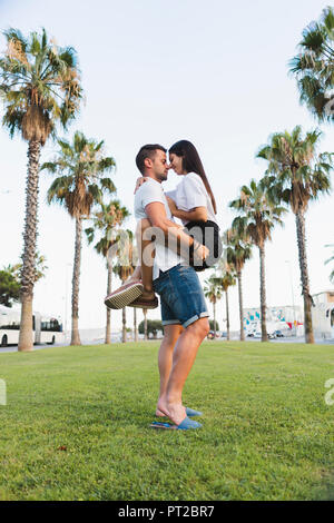 Young couple kissing in park et Banque D'Images