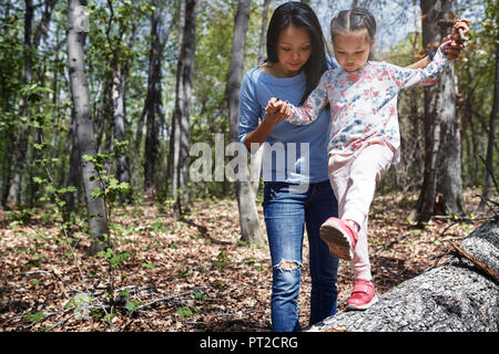 Mère et fille en parc, girl balancing on tree trunk Banque D'Images