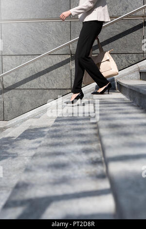 Businesswoman walking en bas, vue partielle Banque D'Images