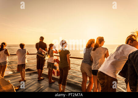 Les passagers à bord d'un navire sur la mer dans le soleil du soir Banque D'Images