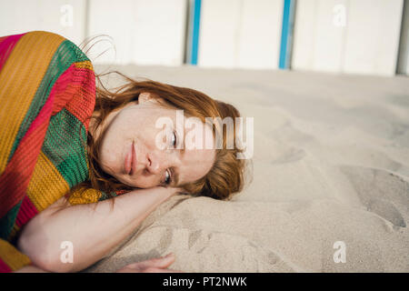 Femme rousse en repos sur la plage de sable Banque D'Images