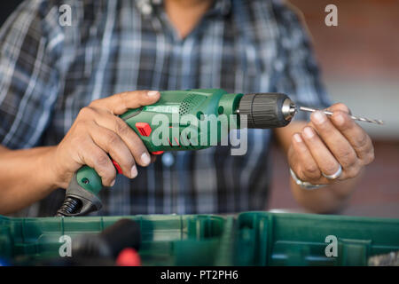 Man's hands holding electric drill Banque D'Images