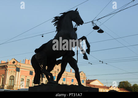 Dresseurs de chevaux par sculpteur Peter Clodt von Jürgensburg (Piotr Klodt) sur le pont Anitchkov à travers le fleuve Fontanka en Saint Petersburg, Russie, représentée en silhouette au coucher du soleil. Banque D'Images