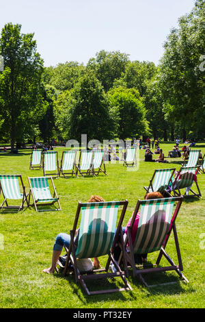 L'Angleterre, Londres, Green Park, les gens vous relaxant dans des chaises longues Banque D'Images