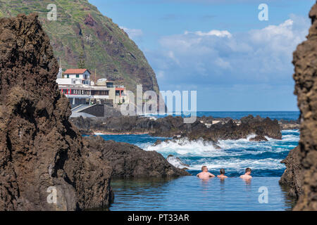 Trois hommes se baigner dans les piscines naturelles de Porto Moniz, Madeira, Portugal, région Banque D'Images