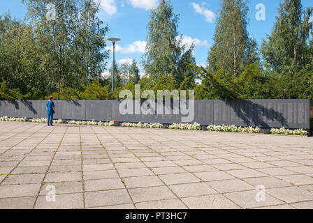 LAPPEENRANTA,Finlande - 8 août, 2016:War Memorial Cemetery. Femme regarde le mur de granit avec les noms de 5500, enterrés dans des charniers et des disparus Banque D'Images