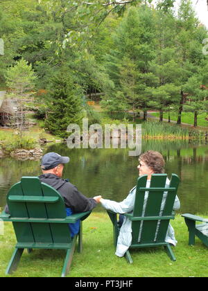 L'entreprise bénéficiant d'un couple marié en vert chaises Adirondack. Banque D'Images