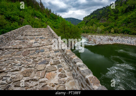 Le célèbre pont du Diable belle antique près de la ville d'Ardino des Rhodopes, Bulgarie, vue partielle de la structure prise au printemps avec les eaux de la rivière verte saturée Banque D'Images