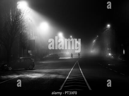 La ville de Cork, Cork, Irlande. 11 Décembre, 2016 Deux personnes traversent la rue que tôt le matin, le brouillard enveloppe le centre commercial du Sud dans la ville de Cork, Irlande. Banque D'Images