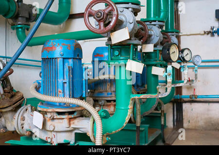 Ancien bleu moteur électrique pour la pompe, vanne et manomètre sur le pipeline. Contexte industriel. Banque D'Images