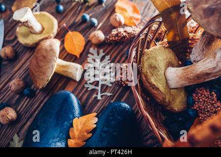 Cèpes dans panier avec des baies et des écrous sur la table en bois. Chasse d'automne avec les chaussures. Récolte d'automne réunis Banque D'Images