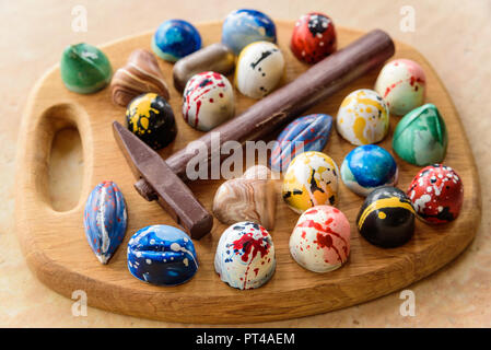 Assortiment de bonbons au chocolat maison et un marteau de chocolat sur un plateau en bois de chêne Banque D'Images