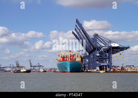 Un grand porte-conteneurs l'Eugen Maersk accostage à le port de Felixstowe étant assisté par deux remorqueurs. Banque D'Images