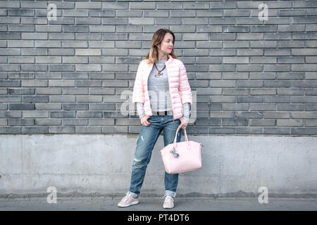 Mode femme portant une veste rose et un jean taille basse. Banque D'Images