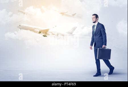 Elegant businessman aller quelque part avec porte-documents et d'avion sur l'arrière-plan Banque D'Images