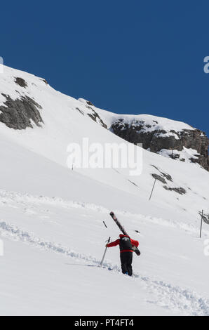 Patrouille de Ski de grimper une pente de montagne transport des grands skis Banque D'Images