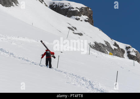 Patrouille de Ski de grimper une pente de montagne transport des grands skis Banque D'Images