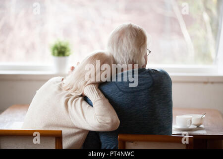 Vue arrière de haut de la famille aimante aux cheveux gris couple de détente à la maison paisible jouissant ensemble le petit déjeuner du matin à la fenêtre à Banque D'Images