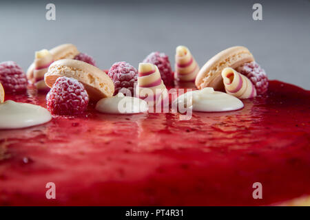 Décoration avec des framboises, des chocolats et des biscuits sur un gâteau Banque D'Images