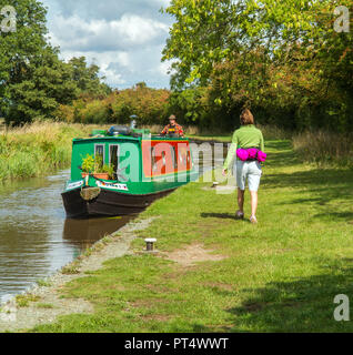 Femme marche le long du chemin de halage du canal de Shropshire Union avec un grand classique en passant près de Wrenbury Cheshire England UK Banque D'Images