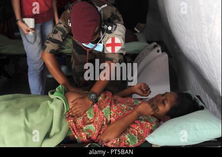 Palu, Indonésie. 7 Oct, 2018. Techniciens médicaux d'examiner une femme enceinte à un abri temporaire en Balaroa, Palu, Central Sulawesi, Indonésie, le 7 octobre 2018. Nombre de décès attribuables à plusieurs tremblements de terre et un tsunami qui a suivi dans la province de Sulawesi central est passé à 1 649, porte-parole de l'agence nationale de gestion des catastrophes Sutopo Edhem Nugroho a déclaré samedi. Ti'Kuncahya Crédit : B./Xinhua/Alamy Live News Banque D'Images