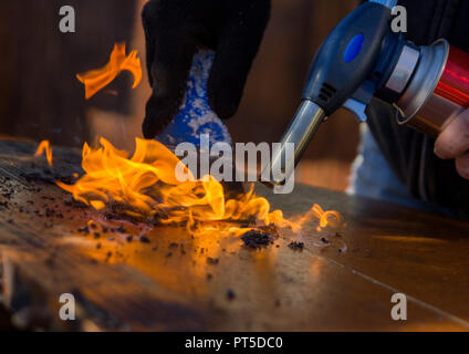 Comptoir de nettoyage de la vieille peinture avec le feu. Le travail du bois, restauration de meubles anciens. Banque D'Images