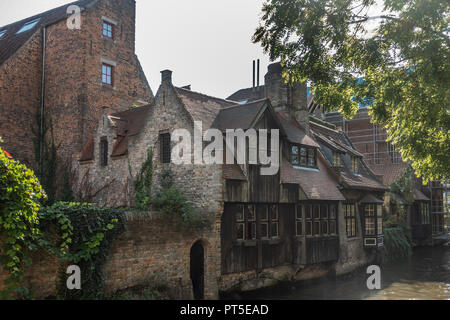 Bruges, Flandre occidentale, Belgique - 19 septembre 2018 : maisons en briques avec façade en bois le long des canaux de Bruges offre des tons de brun sous le ciel d'argent avec s Banque D'Images