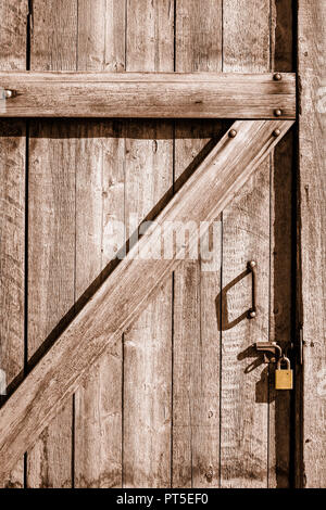 Cette porte est verrouillée de l'extérieur et verrouillé avec un cadenas jaune. C'est un modèle plus ancien - lourde porte de bois de gros morceaux de bois - et Banque D'Images