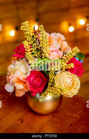 Arrangement de fleurs de roses, hortensia, forsythia et verdure dans un vase sur la table Banque D'Images