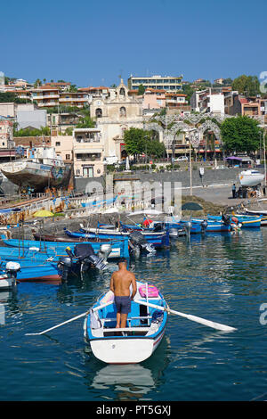 Pêcheur avec barque de pêche à l'Harbour Village Aci Trezza, commune italienne de Aci Castello, Catane, Sicile, Italie Banque D'Images